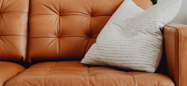 A Tan Leather Sofa with a cushion on it